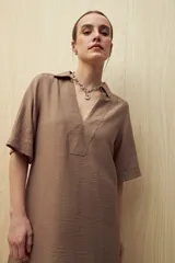 Vestido corto negro de línea relajada con cuello tipo solapa y escote en V profundo, mangas cortas amplias y calce suelto.