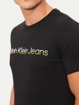 Remera negra de algodón con cuello redondo y mangas cortas. Estampado frontal con el logo "Calvin Klein Jeans" en color dorado.