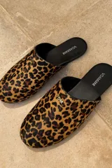 Slippers con estampado animal print, forro y plantilla de cuero negro.