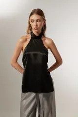 Top negro sin mangas, con cuello halter y espalda descubierta.
