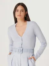 Saco celeste de tejido de punto con cuello en V y cierre frontal con botones.