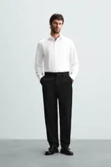 Camisa blanca de manga larga con cuello italiano abierto y puños abotonados. Presenta un corte slim fit y cierre frontal de botonadura.