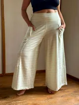 Pantalón palazzo de tiro alto con estampado de rayas horizontales color crema y celeste. Confeccionado en rústico de algodón, con bolsillos laterales, elástico en la espalda y faja ancha en la cintura.