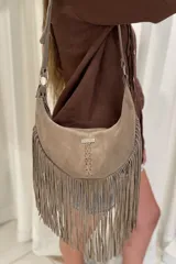 Bandolera de cuero gamuzado color chocolate, con flecos en la parte inferior y correa larga regulable.