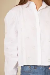 Camisa blanca de mangas largas abullonadas con estampado de corazones.