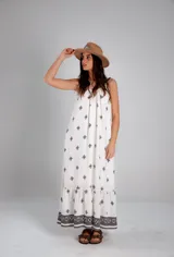Vestido blanco con estampado de cruces negras, sin mangas y corte holgado.