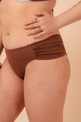 Bombacha de bikini tiro alto color azul marino, con frunce en los costados y confeccionada con fibra LYCRA® XTRA LIFE™.