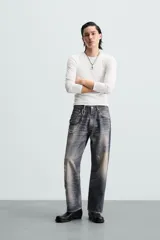 Pantalón de jean azul con lavado gastado, corte holgado y cinco bolsillos.