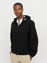 Campera negra de nylon, estilo shell, con capucha y cierre frontal con cremallera. Presenta bolsillos frontales y puños elastizados.