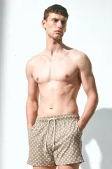 Short de baño color marrón con estampado de palmeras, con cintura elástica ajustable con cordón, bolsillos laterales y trasero con cierre autoadherente.