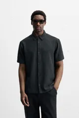 Camisa celeste de corte recto, manga corta y cuello solapa.