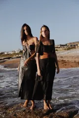 Vestido largo de dos piezas color lila con rayas verticales. El top es de corte cuadrado con mangas cortas acampanadas y elástico en la cintura. La falda es larga con volados y detalles de cuero.