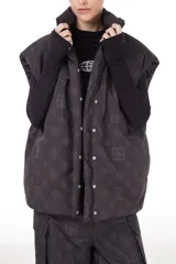 Chaleco negro con estampado de logos, cuello alto, cierre frontal con cremallera y broches a presión ocultos, bolsillos delanteros y cintura ajustable con cordón elástico. Interior de tafeta relleno de guata.