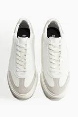 Championes deportivos blancos de estilo retro en tejido revestido con detalles en tejido cepillado gris. Collarín acolchado, lengüeta y cordones. Forro y plantillas de malla. Suelas de goma con diseño.