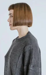 Sweater gris oscuro de manga larga con cuello redondo y paneles laterales con costuras a la vista.