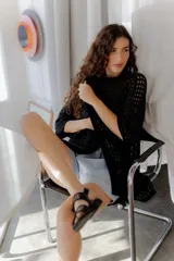 Saco calado negro tejido a máquina, con cuello tipo camisa y mangas 3/4.