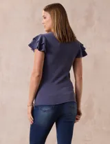 Remera beige de tejido acanalado, con cuello redondo y mangas cortas con volados.