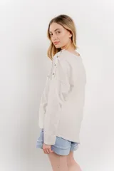 Remera celeste de manga larga con cuello redondo y bolsillo en el pecho.