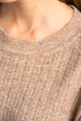 Sweater color beige de tejido texturado, con cuello redondo y mangas largas.