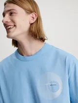 Remera celeste de algodón con corte holgado, cuello redondo y logo gráfico de Calvin Klein estampado en el pecho.