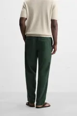 Pantalón largo verde oscuro de algodón con textura, corte recto y cintura elástica ajustable con cordón.