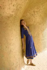 Vestido largo azul con bordados dorados de piedras, cintas e hilos de lurex, escote en V y mangas 3/4.