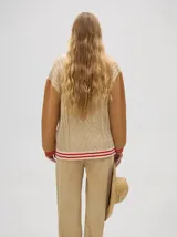 Saco estilo bomber color beige con mangas color ladrillo, tejido a rombos y ochos, con puños bicolor y cierre metalizado.