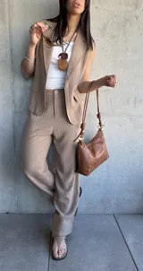 Conjunto sastrero tostado a rayas verticales, compuesto por un pantalón de vestir de corte recto y un chaleco con solapas.