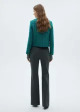 Chaqueta de tweed color verde azulado con cuello redondo, cierre frontal con botones efecto joya, dos bolsillos de parche delanteros, terminaciones deshilachadas y forro interior.