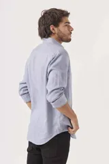 Camisa de lino color blanco, de corte regular, con cuello clásico y mangas largas.