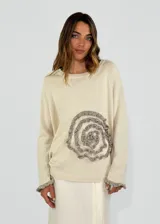 Sweater azul con diseño de flor en el frente y detalles de volados en puños y ruedo.