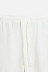 Pantalón largo verde oscuro de algodón con textura, corte recto y cintura elástica ajustable con cordón.