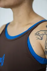 Musculosa deportiva marrón con cuello redondo y sisas con ribete azul. Diseño con doble tela y logo estampado en azul en el frente.