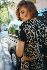 Minifalda ajustada de punto jacquard con estampado animal print en tonos beige y marrón. Presenta corte evasé y cintura con elástico oculto.