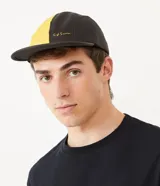 Gorra de cinco paneles bicolor, amarilla y negra, con visera plana y logo bordado en el panel frontal.