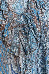 Camisa de manga larga con estampado cachemir en tonos celeste, azul y marrón. Presenta escote en V con volantes y lazos.