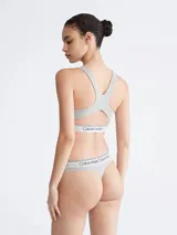 Corpiño deportivo Calvin Klein color gris, sin relleno, con escote en U, espalda cruzada y banda elástica con logo.