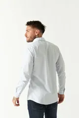 Camisa celeste a cuadros, de corte slim fit, manga larga y logo bordado. Confeccionada en 100% algodón.