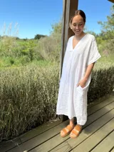 Vestido largo azul marino de lino italiano, con escote en V, mangas cortas y bolsillos laterales.