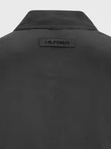 Campera negra con cuello doblado y cierre frontal, cuenta con dos bolsillos laterales y logo de Tommy Hilfiger bordado.