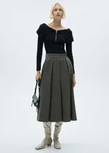 Falda midi gris de tejido de lana con diseño de tablas y corte evasé.