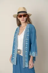 Chaqueta suelta de jean azul con bordados en hilo de seda color blanco.