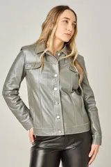 Campera tipo jeanera de cuero color peltre, con cuello clásico, cierre frontal con botones metálicos y dos bolsillos con solapa en el pecho.