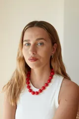 Collar de cuentas esféricas grandes de acrílico blanco, ensartadas en un cordón claro.