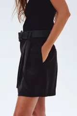 Short negro de sarga con pinzas, tiro alto, cinturón trenzado ancho, cierre con botón y corchete ocultos, bolsillos laterales y traseros.