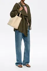 Bolso tote negro de cuero vacuno con doble asa corta y correa de tela extraíble. Interior con tres compartimentos y bolsillo con cremallera. Logo metálico de la marca en el frente.