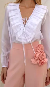 Blusa blanca traslúcida con escote en V y volados.
