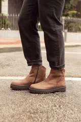 Bota corta de cuero color marrón, con suela de goma negra y cierre lateral con cremallera.