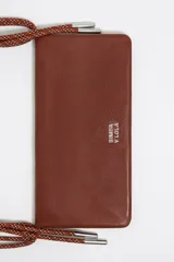 Minibolso negro de estructura blanda con asa de mano de cordón rojo y asa larga extraíble. Presenta logo metálico, acabados metálicos y cierre con botón de presión. Incluye tarjetero interior e interior con logo estampado.