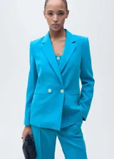 Blazer celeste con solapas de muesca, cierre cruzado con doble botonadura y bolsillos delanteros con solapa. Forro interior y mangas largas.